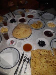 einen Tisch mit Teller mit Lebensmitteln drauf in der Unterkunft maison d hote timentour in Tiguissas