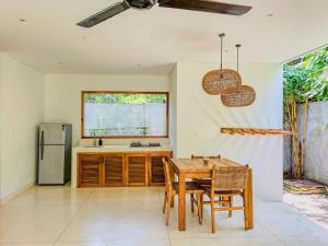 a kitchen with a table and chairs and a refrigerator at Marlaca Villas - Pampita - One bed Kuta Central in Kuta Lombok