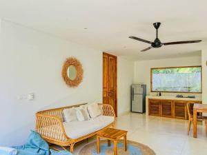 a living room with a rattan couch and a kitchen at Marlaca Villas - Pampita - One bed Kuta Central in Kuta Lombok