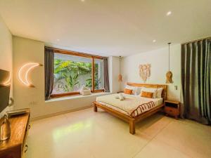 a bedroom with a bed and a large window at Marlaca Villas - Pampita - One bed Kuta Central in Kuta Lombok