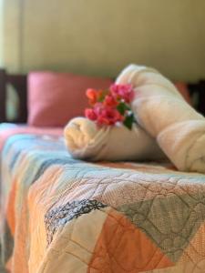 a person holding a flower on a bed at Casa Heliconia in Puerto Jiménez