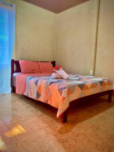 a bedroom with a bed with a stuffed animal on it at Casa Heliconia in Puerto Jiménez