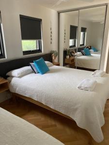 1 dormitorio con 2 camas y un espejo grande en McCrae Beach Front Villa Unit 1, en McCrae
