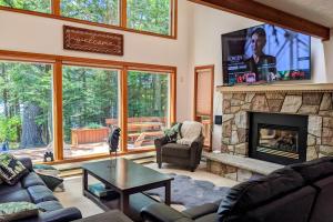 a living room with a fireplace and a tv at Tranquil Waterside by AvantStay Lakefront Dock Game Room Views in Pocono Summit