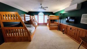 two bunk beds in a room with green walls at Tranquil Waterside by AvantStay Lakefront Dock Game Room Views in Pocono Summit