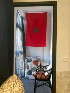 a room with a flag and a table and a chair at Pied sur mer "Un paradis à bas prix" in Tamaris