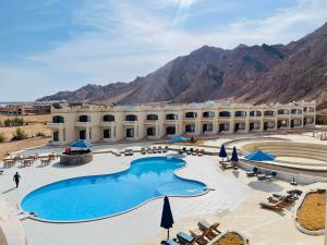 un resort con una grande piscina e montagne sullo sfondo di Zain Dive Inn a Dahab
