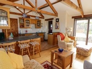 a kitchen and living room with a counter and chairs at Casa Mia in Goodwick