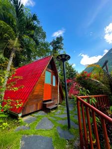 a small house with a red roof next to a lamp at Green Paradise Bungalows in Las Palmas
