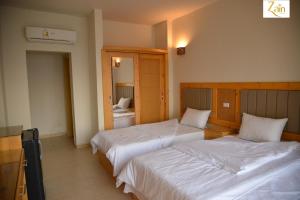 una camera d'albergo con due letti e uno specchio di Zain Dive Inn a Dahab