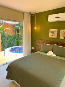 a bedroom with a bed and a large window at Bangalô Villas do Pratagy in Maceió