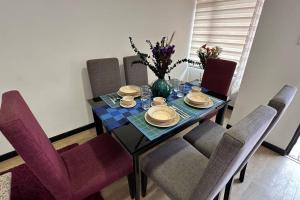 a dining room table with chairs and a vase of flowers at Amplio e impecable apartamento en Cajicá in Cajicá