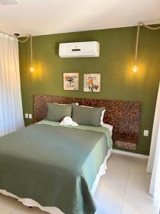 a bedroom with a bed with a green wall at Bangalô Villas do Pratagy in Maceió