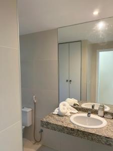 a bathroom with a sink and a mirror at Bangalô Villas do Pratagy in Maceió