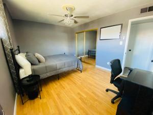 una camera con letto, scrivania e ventilatore a soffitto di Munoz Home a Yuma