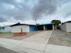 une maison avec un garage bleu et blanc dans l'établissement Munoz Home, à Yuma