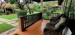 2 chaises assises sur une terrasse couverte avec une clôture dans l'établissement Liberty Dive Resort, à Tulamben