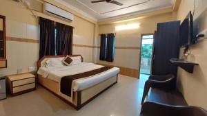 a bedroom with a bed and a television in it at Hotel Star inn Sea View Hotel GRG in Puri