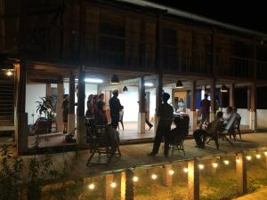 Ba Be Retreat house في Bak Kan: مجموعة من الناس تقف على سطح السفينة في الليل