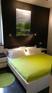 a bedroom with a green bed with a painting on the wall at Apartment Rhein Main in Hochheim am Main
