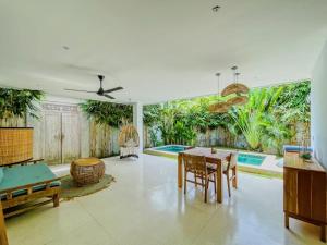 sala de estar con mesa y piscina en Marlaca Villas Lombok - Margalida, en Kuta Lombok