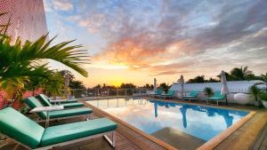 una piscina con tumbonas y una puesta de sol en The Tides Hotel Boracay, en Boracay