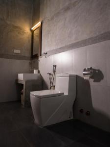 Łazienka z białą toaletą i umywalką w obiekcie Rise & Set Arugam bay w mieście Arugam Bay