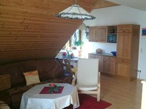 a living room with a table and a couch at Däumler "House Am Weißwald" in Breitenbrunn