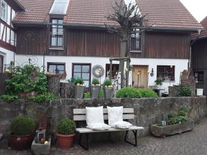 a bench in front of a house with pillows on it at Stork's Nest Modern retreat in Eichenzell