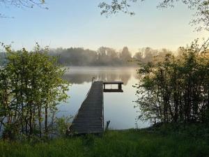 WuthenowにあるHäuschen über der Lankeの霧の日の湖の中の桟橋