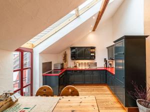 a kitchen with black cabinets and a red counter top at Stork's Nest Modern retreat in Eichenzell