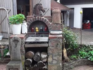 a outdoor oven with a horse statue in a yard at Stork's Nest Modern retreat in Eichenzell