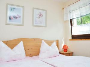 a bedroom with a bed with white pillows and a window at Evening sun Modern retreat in Cunewalde