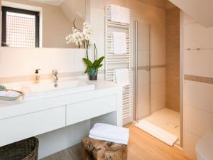 ein weißes Badezimmer mit einem Waschbecken und einem Spiegel in der Unterkunft Reethuus Nord Modern retreat in Juist