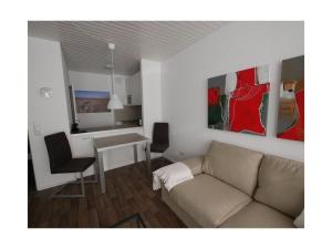 ein Wohnzimmer mit einem Sofa und einem Tisch in der Unterkunft "Schnepfenweg" 39 Merchant in Horumersiel
