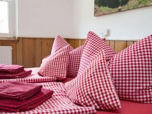einen Haufen roter und weißer Kissen auf einem Bett in der Unterkunft Gießler Modern retreat in Biberach