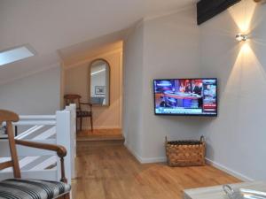 a living room with a flat screen tv on the wall at Suite Nuss Modern retreat in Bad Wiessee