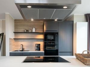 a kitchen with a sink and a stove top oven at Reethuus Süd Modern retreat in Juist