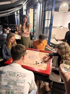 Un groupe de gens jouant à un jeu sur une table dans l'établissement Hangover Hostels Ella, à Ella