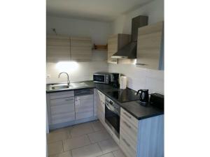 a kitchen with a sink and a stove top oven at Seagull Street 21 Merchant in Horumersiel +7 photos