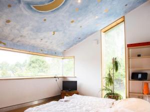 a bedroom with a bed and a blue ceiling at House by the Park Modern retreat in Bispingen