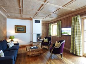 a living room with a blue couch and chairs at Suite Linde Modern retreat in Bad Wiessee