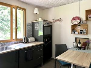 Una cocina con un refrigerador negro y una mesa. en Het kleine droomhuisje, en Vendays-Montalivet