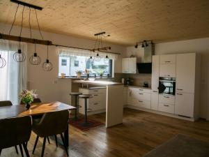 a kitchen with white cabinets and a wooden table at Holiday home Birx Rhön in Birx