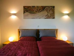 una camera con due letti con lenzuola rosse e due lampade di Holiday home Birx Rhön a Birx