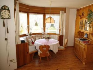 a dining room with a table and a clock at Bärenhüsli No 7 in Titisee