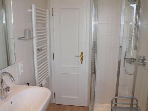 a white bathroom with a shower and a sink at Haus Hoppel - FeWo ground floor in Rantum