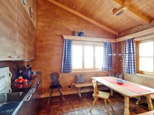 eine Küche mit Holzwänden sowie einem Tisch und Stühlen in der Unterkunft Chestnut in chalet Bergerhöh in Bad Wiessee