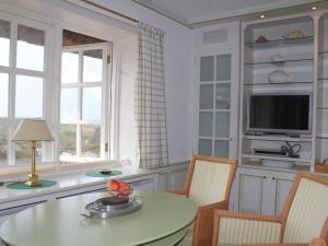 a kitchen with a table and chairs and a television at Haus Hoppel - FeWo ground floor in Rantum