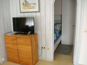 ein Schlafzimmer mit einem TV auf einer Kommode und einem Schrank in der Unterkunft Bärenhüsli No 4 in Titisee